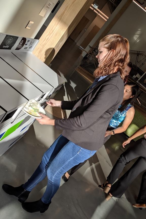 A student discarding materials in the appropriate bin.