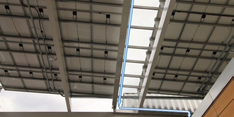 Portions of the solar canopy that overhang the roof have gutters that channel rainwater to the roof, where the water is drained into the cistern.