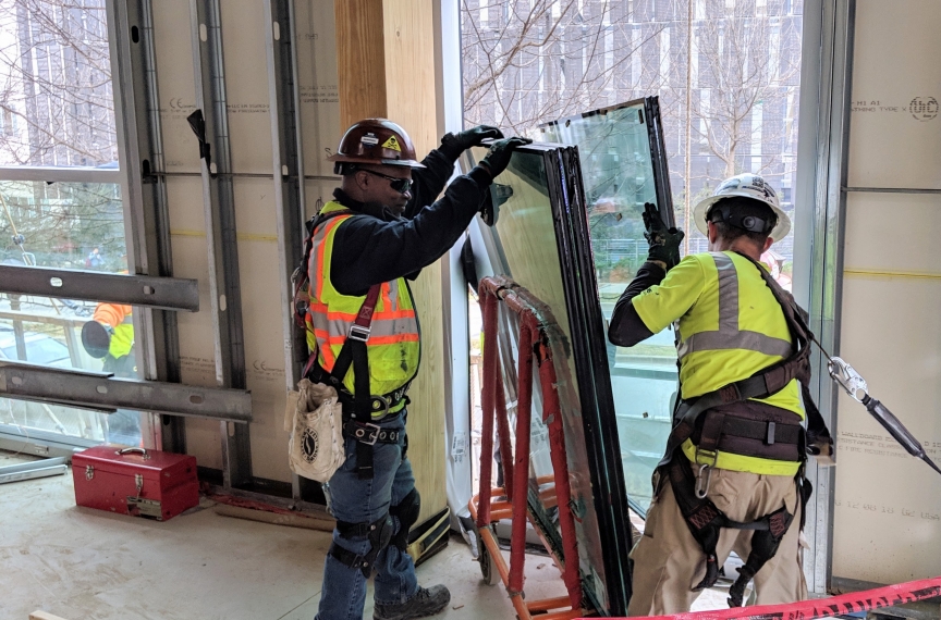 Installation of triple pane windows. Both half-inch spaces between the three quarter-inch panes are filled with argon gas, which has greater insulating qualities than air.