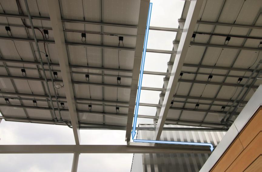 Portions of the solar canopy that overhang the roof have gutters that channel rainwater to the roof, where the water is drained into the cistern.